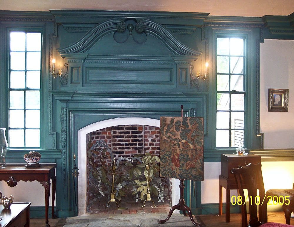 A fireplace with blue walls and a painting on the wall.