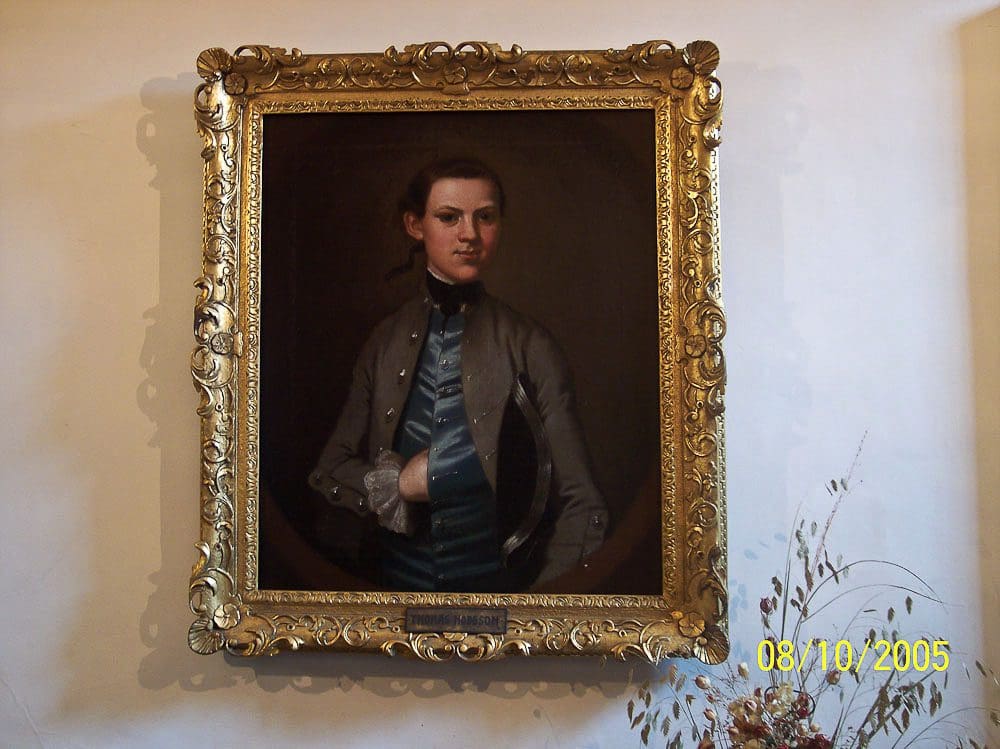 A painting of a man in a suit hanging on the wall.