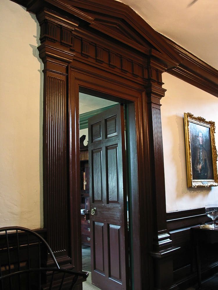 A door way with a mirror and chair in it