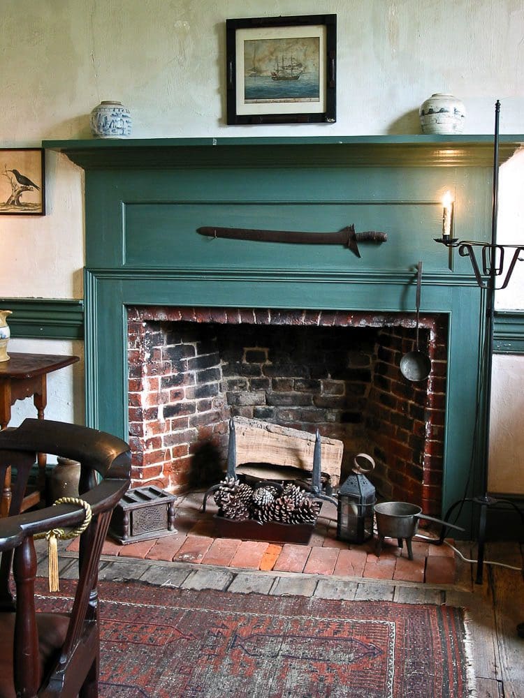 A fireplace with a brick surround and green mantle.