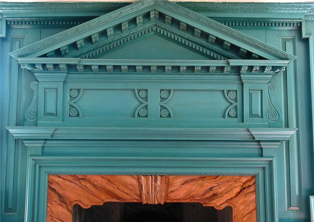 A fireplace mantle with a blue finish and wood trim.