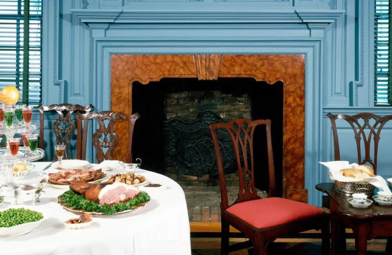 A table with food on it in front of a fireplace.