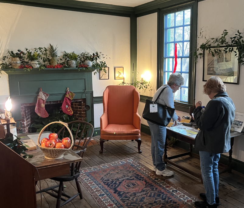 Two people standing in a room with furniture.