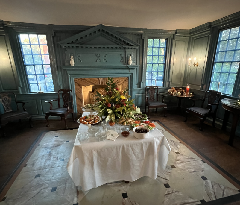 A table with food on it in front of a fireplace.