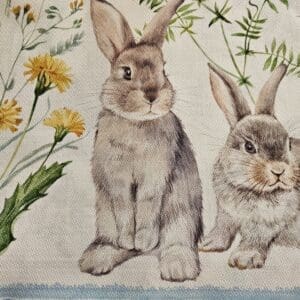 Two rabbits with dandelions and greenery.